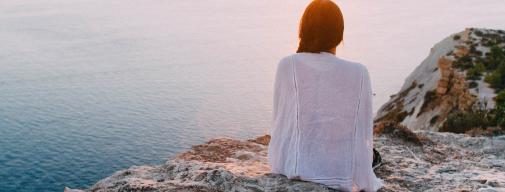 women sitting on rock absorbing chakra energy