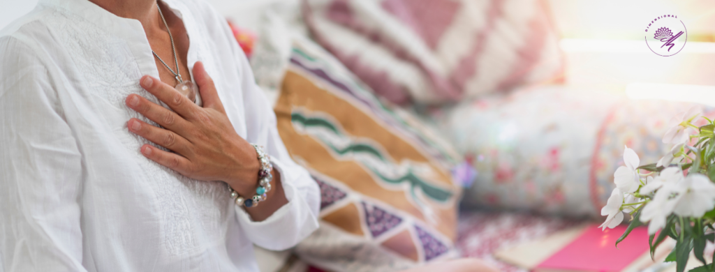 woman with hand on heart meditating on her lower chakras